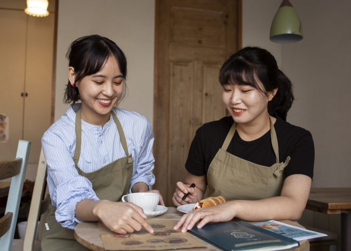 young-women-arranging-their-cake-shop